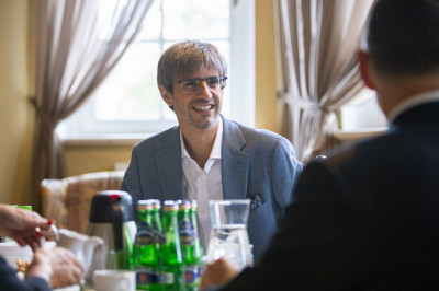 Oriol Marquet Sardà siedzi przy stole i uśmiecha się